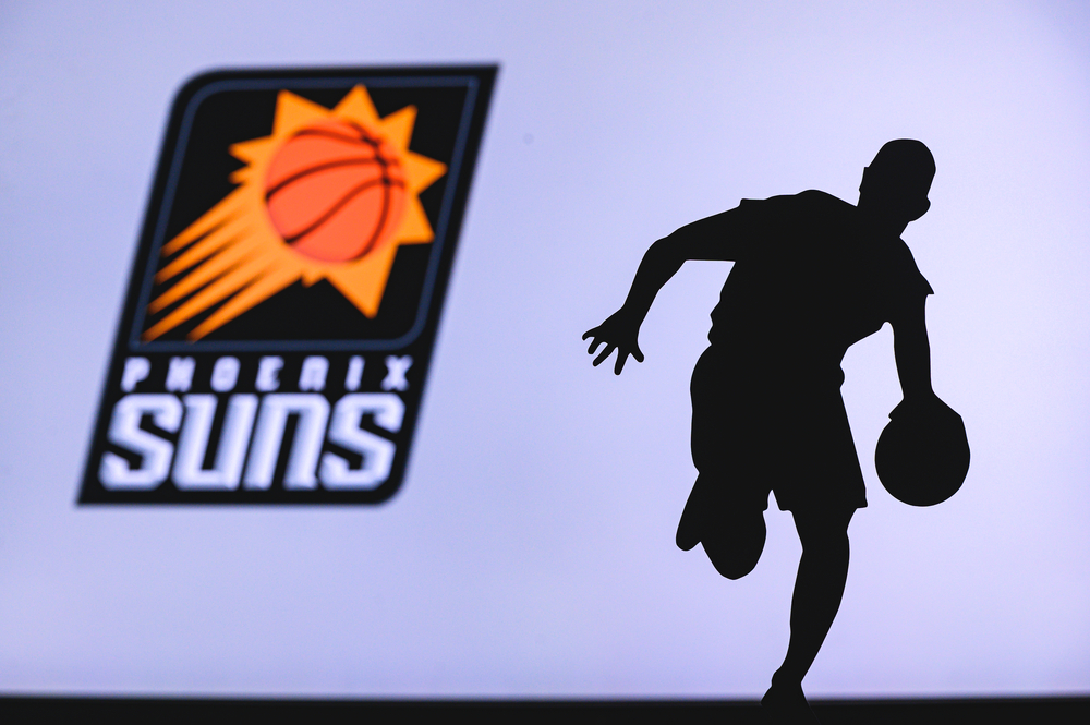 Phoenix Suns basketball club logo and silhouette of young basketball player. Sport wallpaper, white edit space in background.